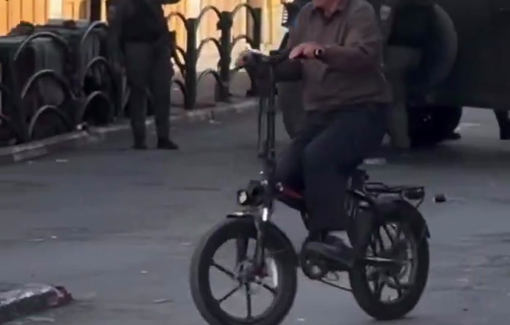 Thumbnail preview image for the video titled: Defiance and daily Life: children and elderly cycle amid Israeli soldiers