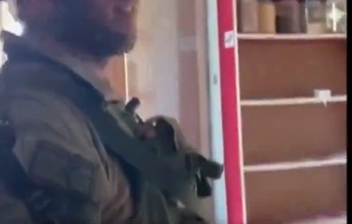 Thumbnail preview image for the video titled: Soldier proceeds to mock the Muslim prayer rugs and garments in the store, throwing them on the ground